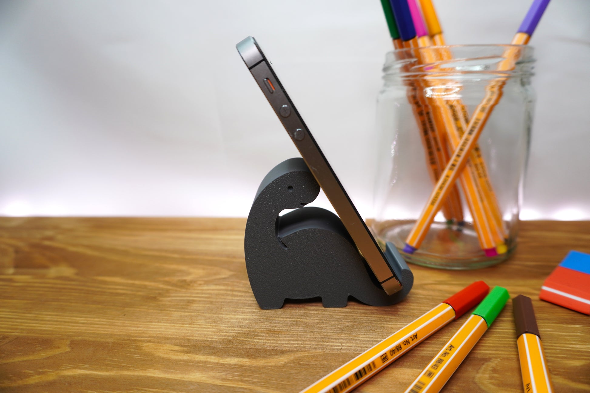 Handyhalterung im Dinosaurier-Stil in verschiedenen Farben, perfekt für den Arbeitsplatz