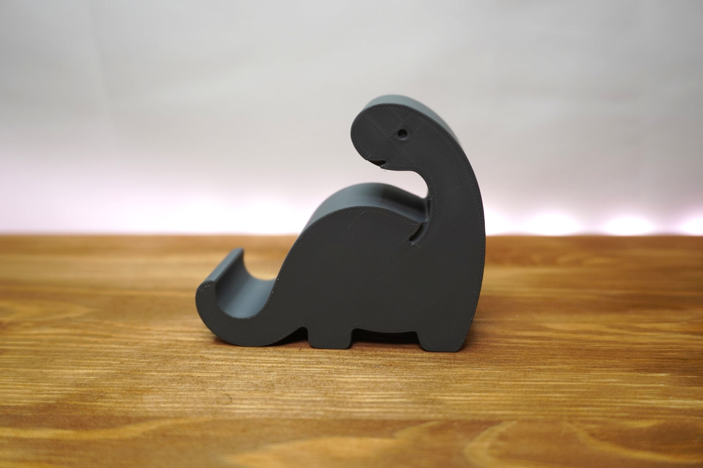 Dinosaurier-Handyhalterung auf dem Schreibtisch, funktional und dekorativ
