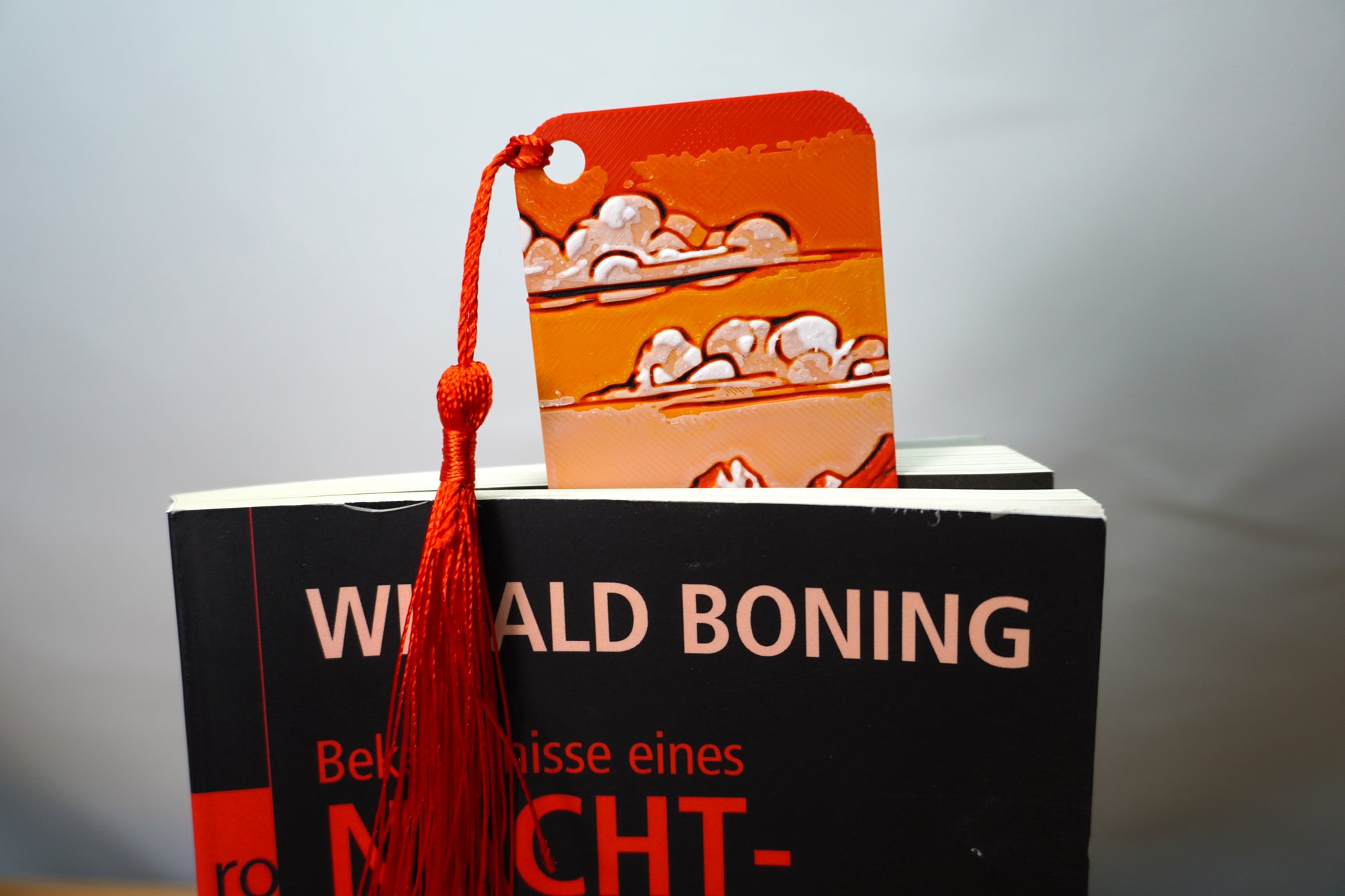 Nahaufnahme des Lesezeichens mit Berglandschaft und grasender Kuh im Vordergrund, wählbar mit Quaste