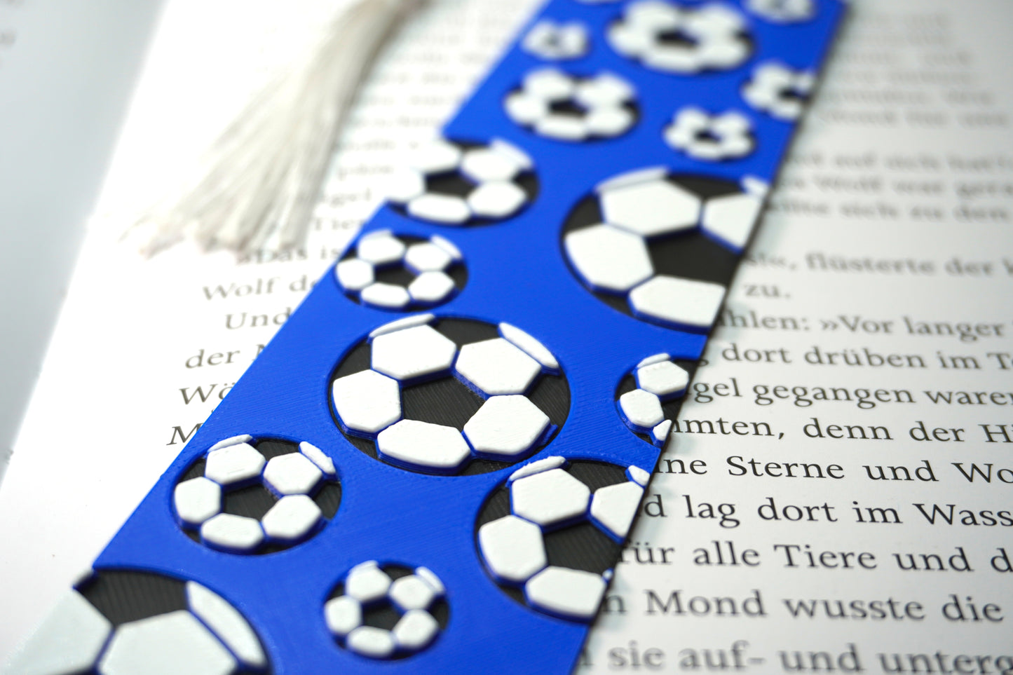 Nahaufnahme des Lesezeichens mit Fußball-Muster in verschiedenen Größen und farbigem Hintergrund