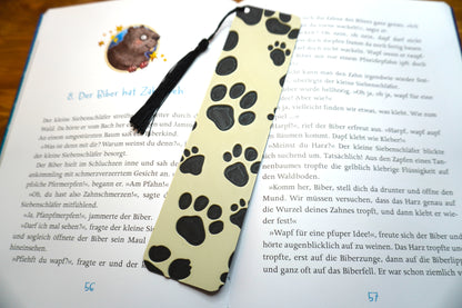 Lesezeichen mit schwarzem Hundepfoten-Design auf beigem Hintergrund, wahlweise mit Quaste