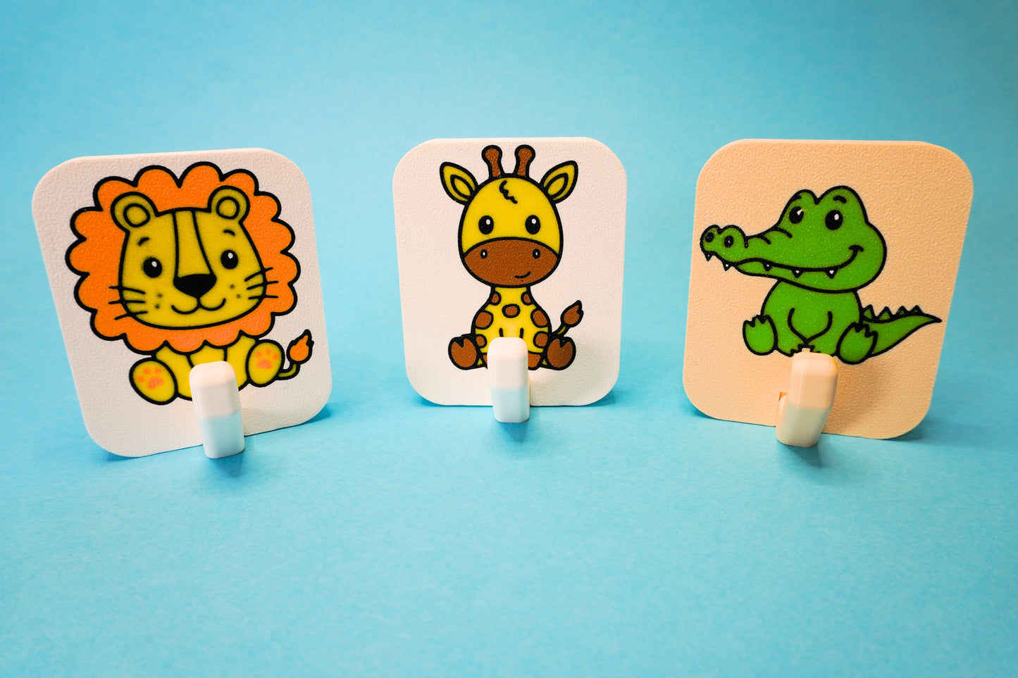 Mehrere Safari-Handtuchhalter in verschiedenen Farben an Wand – buntes Badezubehör für Kinder