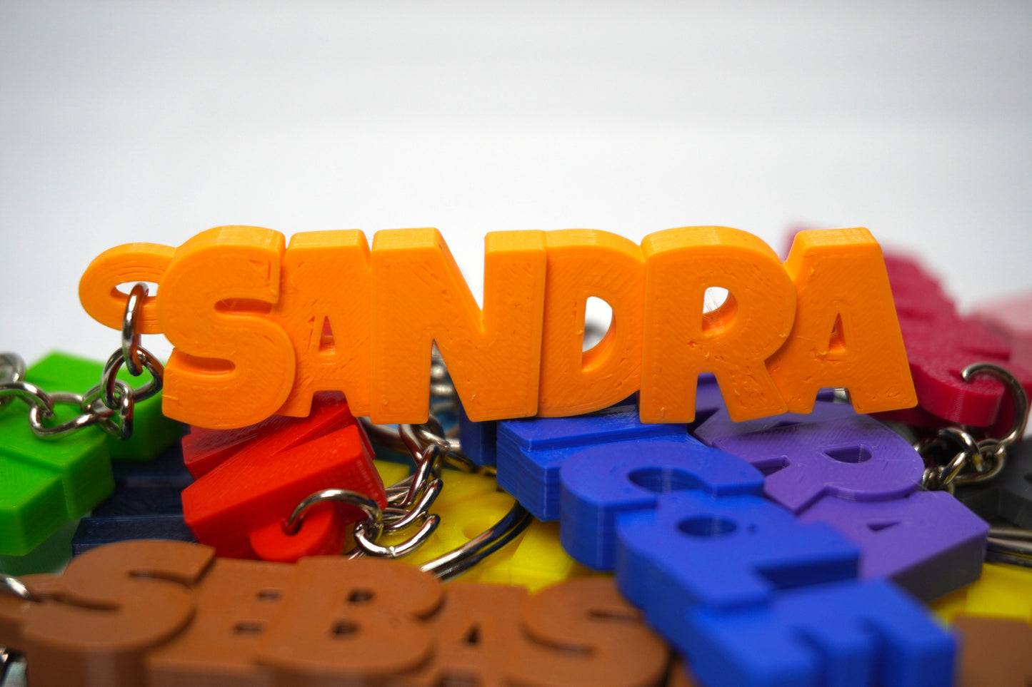 Schlüsselanhänger in der Farbe Orange mit personalisiertem Schriftzug, geliefert mit Schlüsselring und Kette